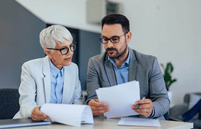 Mature woman and young man reviewing documents