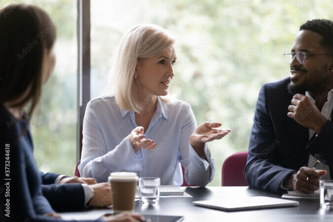 female and two coworkers at a conference room table